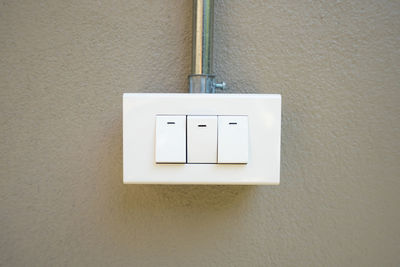 Close-up of electric lamp on wall at home