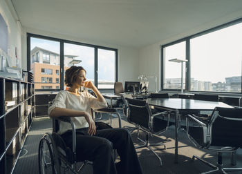 Disabled business woman sitting in wheelchair, smiling