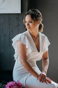 Beautiful woman sitting against wall