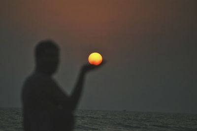 Reflection of man in sea against sky