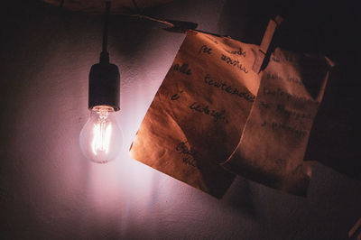 High angle view of illuminated light bulb hanging on table