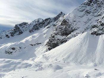 Scenic view of snowcapped mountain against cloudy sky