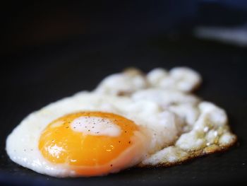 Close-up of fried egg over black background