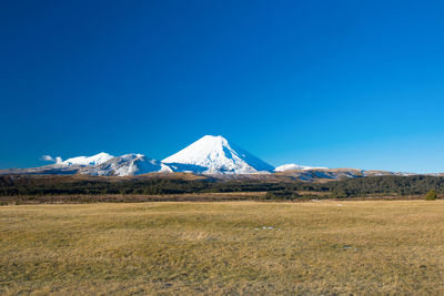 Scenic view of snowcapped mountains against clear blue sky