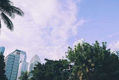 Low angle view of trees and buildings against sky