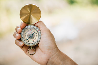 Close-up of hand holding navigational compass