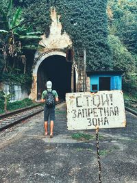 Rear view of woman with text against building