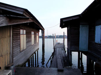 Wooden pier amidst buildings against clear sky