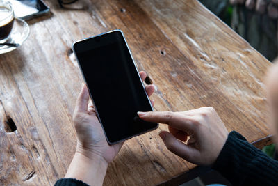 High angle view of person using mobile phone on table