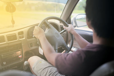 Side view of man driving car