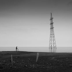 Person standing at beach against sky