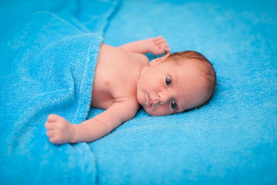 Portrait of cute baby lying on bed