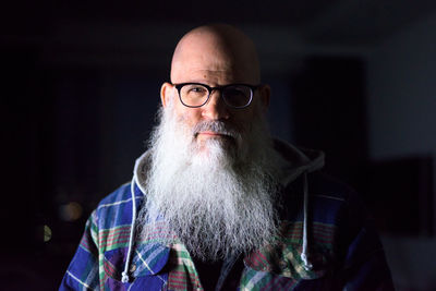 Portrait of man wearing eyeglasses against black background