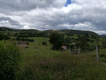 Scenic view of grassy landscape against cloudy sky