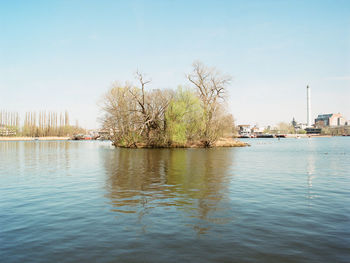 Scenic view of river against sky in city