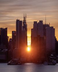 Modern buildings against sky during sunset