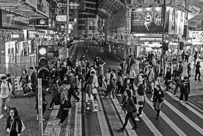 People on road intersection in city at night