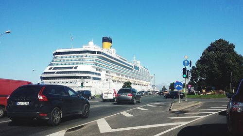 Cars on road in city against clear sky