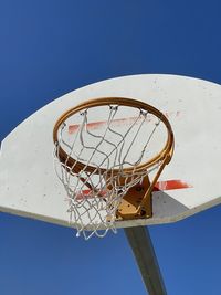 Low angle view of basketball hoop against blue sky