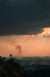 Silhouette of man looking at sunset