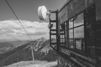 Satellite dishes on building against mountains