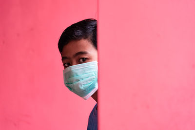 Portrait of young man against pink background