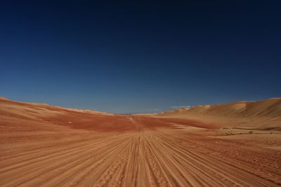 Scenic view of desert against clear blue sky