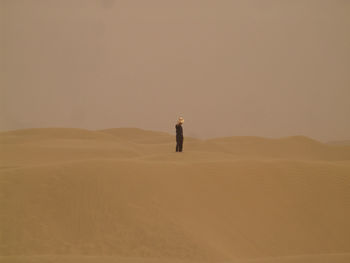 Man standing in desert against clear sky