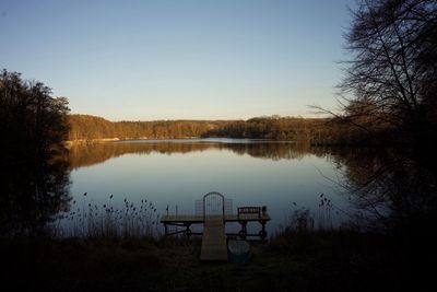 Scenic view of lake against clear sky at sunset