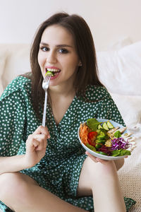 Portrait of young woman eating food