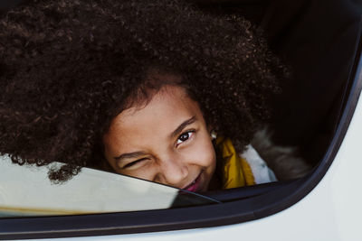 Close-up portrait of girl winking eye in car