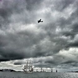 Low angle view of airplane flying against cloudy sky