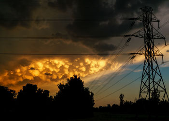 Silhouette electricity pylon against sky during sunset