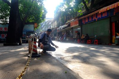 Man sitting on street in city