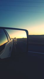 Cropped image of train against sky at sunset