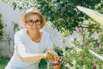 Portrait of smiling mature woman against plants