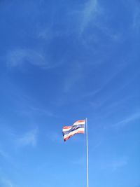 Low angle view of flag against blue sky