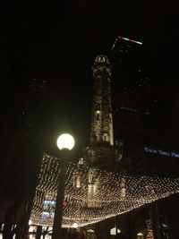 Low angle view of illuminated tower at night