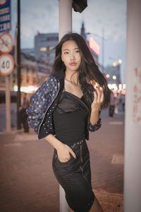 Young woman standing on street at night