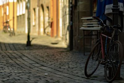 Bicycle parked on footpath by street in city