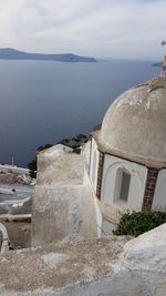 Scenic view of sea by buildings against sky