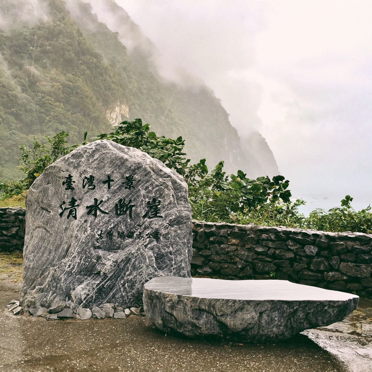 text, tranquility, sky, art, water, rock - object, nature, art and craft, tranquil scene, day, stone material, creativity, western script, scenics, outdoors, stone - object, stone, tree, human representation, no people