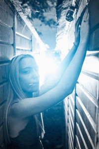 Portrait of young woman standing by railing