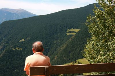 Rear view of man on mountain against sky