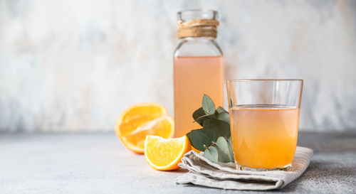 Cold and refreshing fresh orange juice in glass and bottle with fresh orange