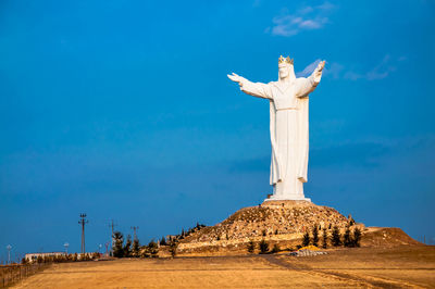 Low angle view of statue against blue sky