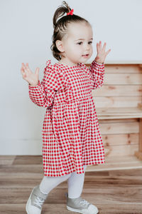 Portrait of cute girl standing on hardwood floor