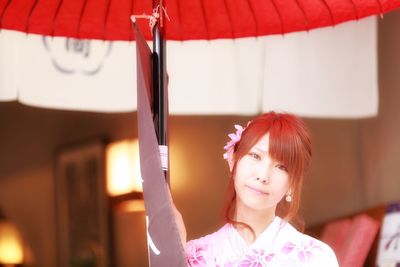 Portrait of woman in kimono under umbrella