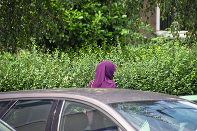 Rear view of woman wearing hijab by car