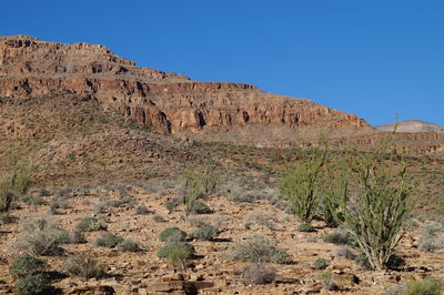 Low angle view of rock formation against clear blue sky